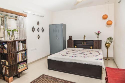 Homestay for Women في كويمباتور: غرفة نوم مع سرير ورف كتاب