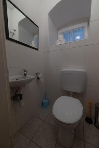 a bathroom with a white toilet and a sink at Villa Tabody in Révfülöp