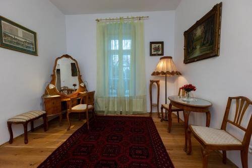a living room with a table and chairs and a mirror at Villa Tabody in Révfülöp