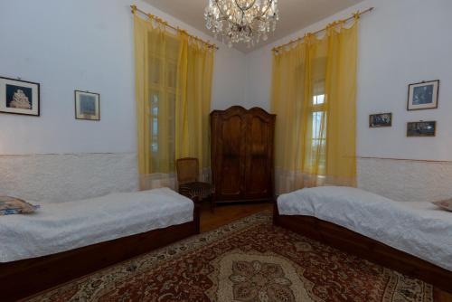 a bedroom with two beds and a chandelier at Villa Tabody in Révfülöp