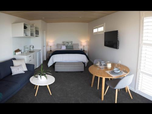 a room with a bed and a couch and a table at Wake Field Views in Nelson