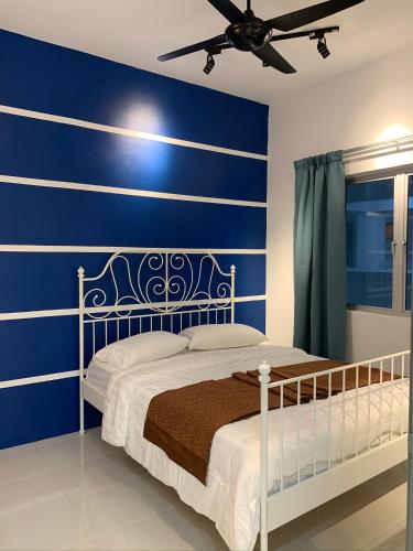 una camera blu con un letto e un ventilatore a soffitto di Garden Sky Homestay a Malacca