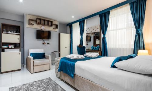 - une chambre avec un grand lit et une chaise dans l'établissement Vilenza Hotel, à Londres