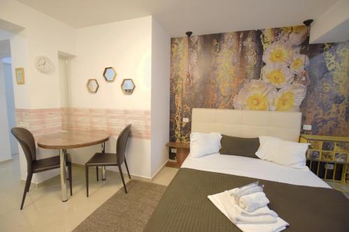 a bedroom with a bed and a table with chairs at Decebal Residence Apartments in Bucharest