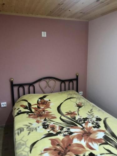 a bedroom with a bed with a floral bedspread at маленькое шале в с.Строенцы in Stroieşti