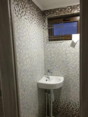 a bathroom with a white sink and a window at маленькое шале в с.Строенцы in Stroieşti