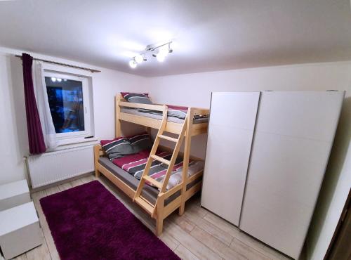 Zimmer mit 2 Etagenbetten und einem Kühlschrank in der Unterkunft Apartment for your Holiday in Ramingstein