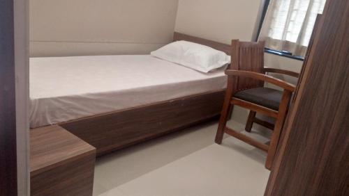 1 dormitorio pequeño con 1 cama y 1 silla en LEMON RESIDENCY By Chungath, en Trichūr
