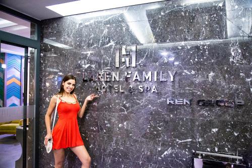 a woman in a red dress standing in front of a wall at Laren Family Hotel & Spa - Boutique Class in Antalya