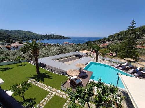 uma vista para a piscina e para o oceano a partir de uma casa em Panormos Beach Hotel Skopelos em Panormos