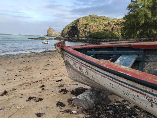 a boat sitting on a beach next to the ocean at COCO MANGO Villa in Trèfles