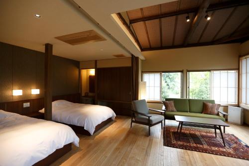 a bedroom with a bed and a bed and a couch at Yumeguri no Yado Yoshiharu in Izunokuni
