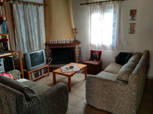 a living room with two chairs and a television at Cosy house in Galaxidi in Galaxidhion