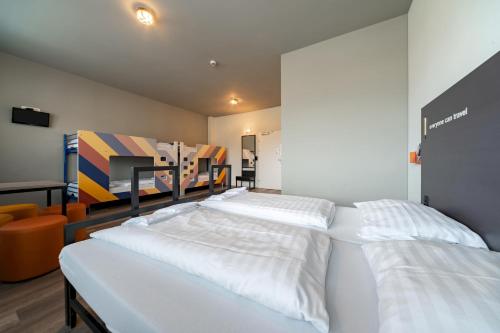 a room with three beds in a room at a&o Graz Hauptbahnhof in Graz