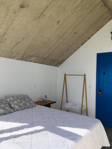 a bedroom with a large bed and a blue door at CASA DO MAR in Jardim do Mar