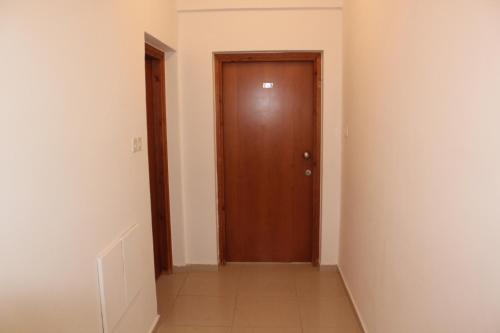 an empty hallway with a wooden door and stairs at Galatia's Court in Paphos City