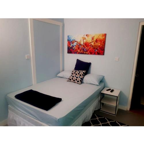 łóżko w pokoju z obrazem na ścianie w obiekcie Careffe Suites Unit 4 w mieście Cap Estate