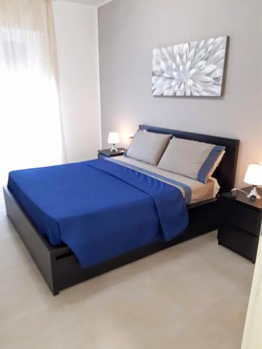 a bedroom with a large bed with blue sheets and pillows at Suite Rent Milan 2 in Milan