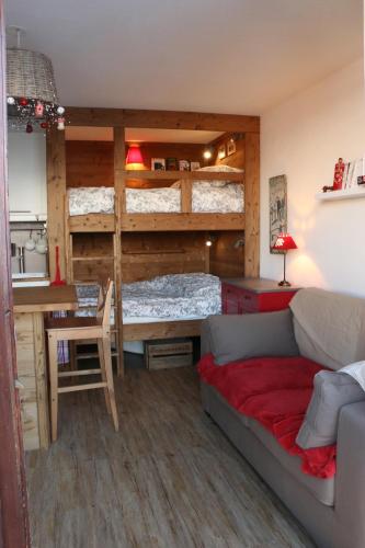 a room with a couch and a bed and a desk at Appartements Immeuble Zodiaque in Le Corbier