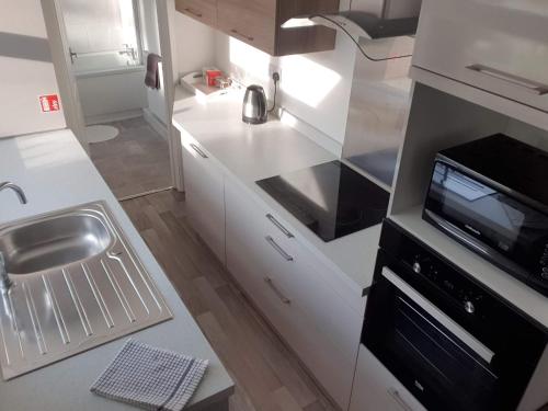 a small kitchen with a sink and a microwave at Lime Cottage Short Term Accommodation Digs in Sunderland
