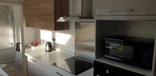 a kitchen with a microwave and a counter top at Lime Cottage Short Term Accommodation Digs in Sunderland