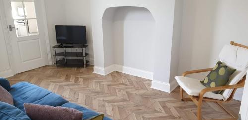 a living room with a wooden floor and a tv at Lime Cottage Short Term Accommodation Digs in Sunderland
