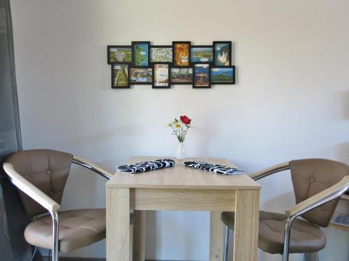 a table with two chairs and a vase of flowers on it at Bülows kleines Ferienhaus in Thiessow