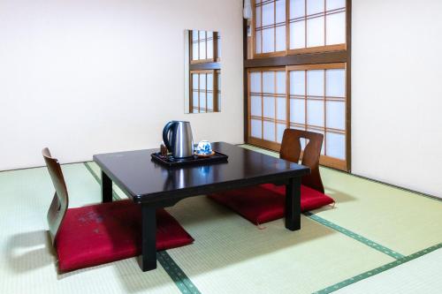 a table with two chairs and a telephone on it at Sakadojo in Minami Uonuma
