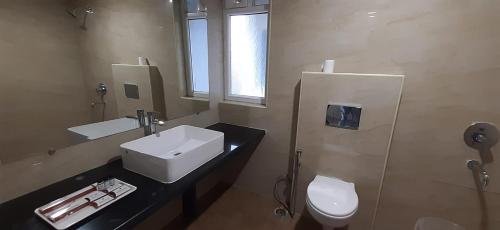 a bathroom with a sink and a toilet at Aranya Resort by Mrugavani in Shamirpet