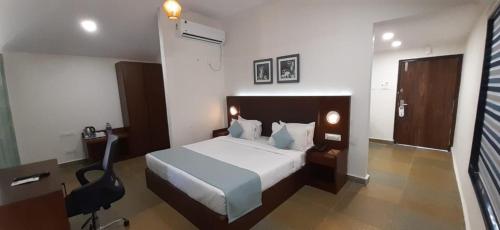 a bedroom with a bed and a desk and a chair at Aranya Resort by Mrugavani in Shamirpet