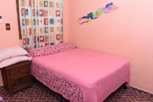 2 camas en una habitación con paredes rosas en Cancun Guest House 1, en Cancún