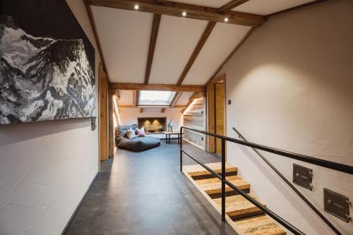 um corredor com escadas e um sofá num quarto em Gästehaus Richter em Grainau