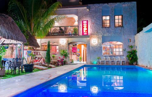 een huis met een zwembad voor een gebouw bij Hotel Mayahau Coba in Cobá