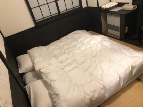 a large white bed in a room at Schanze Nozawa in Nozawa Onsen