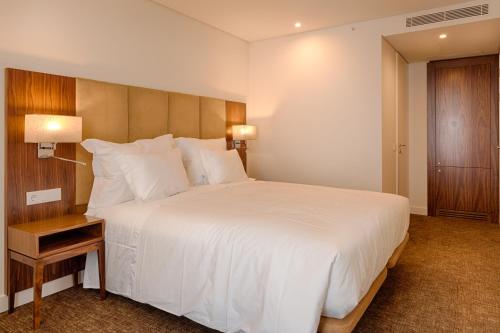 a hotel room with a bed and a dresser at Hotel Premium Porto Downtown in Porto