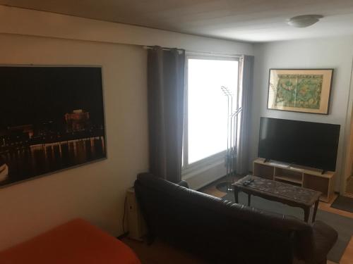 a living room with a couch and a television at Hotel Lamminpää in Tampere