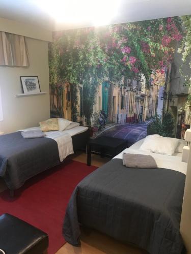 a room with two beds and a mural of a street at Hotel Lamminpää in Tampere