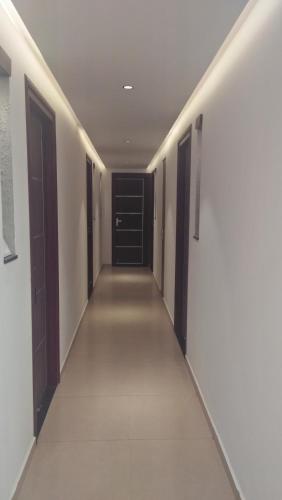 a hallway with black doors and white walls at LEMON RESIDENCY By Chungath in Trichūr