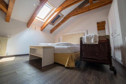 a bedroom with a bed in a attic with a window at Alpen Hotel Eghel in Folgaria