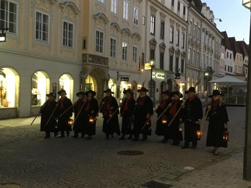 a group of people walking down a street with torches at New flat in old town+garage in Steyr