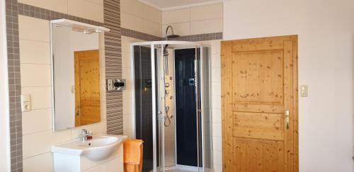 a bathroom with a sink and a shower and a mirror at Huberhof im Almenland in Sankt Kathrein am Offenegg