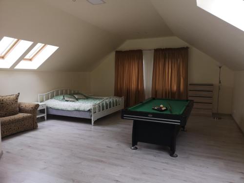 a bedroom with a bed and a pool table at Apartamentai Rimkuose in Klaipėda