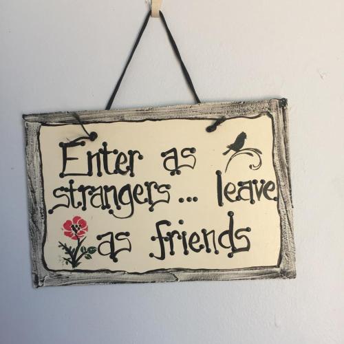 a sign that says enter as a stranger leave as friends at Barberton BnB in Barberton