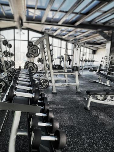 a gym with rows of dumbbells in a room at Livefortuna Hotel in Beijing