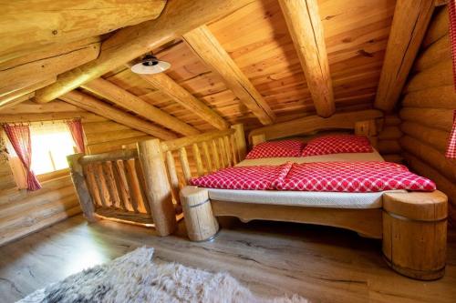 a bed in a room in a log cabin at Srub RANCH NA HRANICI in Baška