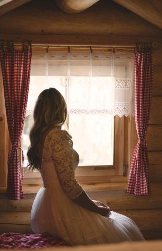 a woman sitting in front of a window at Srub RANCH NA HRANICI in Baška