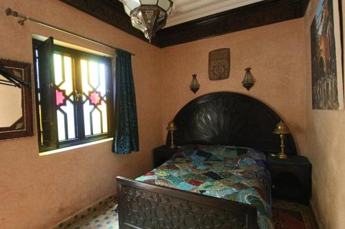 een slaapkamer met een bed en een raam bij RIAD MAKENE MOUCHKILL in Marrakesh