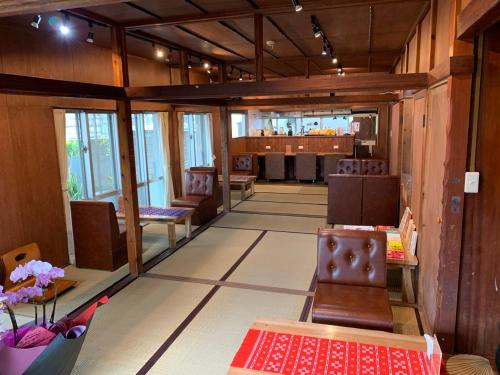 ein Zimmer mit Stühlen und einer Bar im Hintergrund in der Unterkunft 宿＆喫茶 アガリメージョー in Uruma