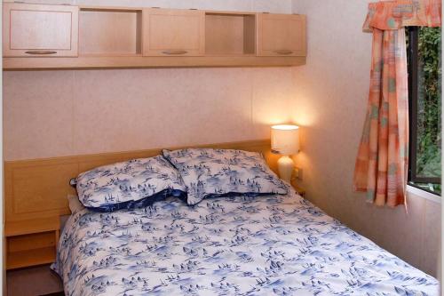 a bedroom with a bed with a blue and white comforter at Violet Mays Retreat in Starcross