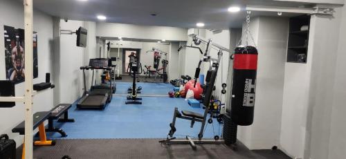 a gym with several tread machines and a punching bag at The Soni'otel in Hāora